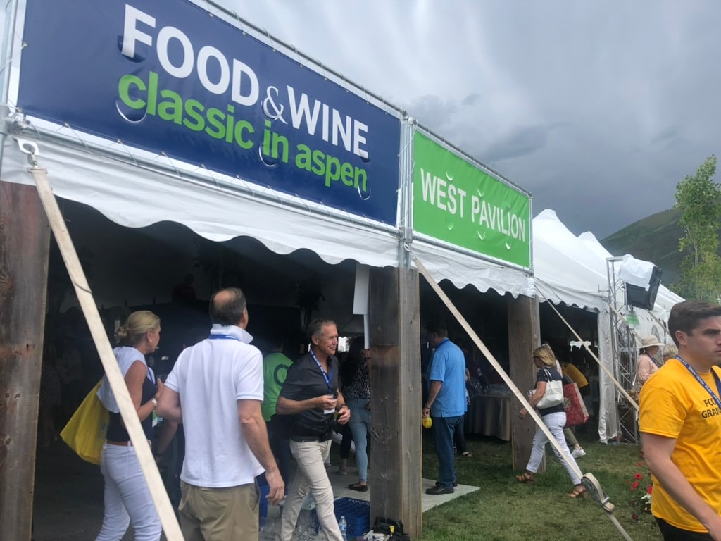 Food and Wine Classic in Aspen event sign with festival tents and attendees